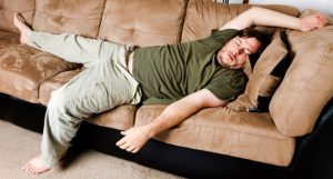 pudgy man asleep on couch